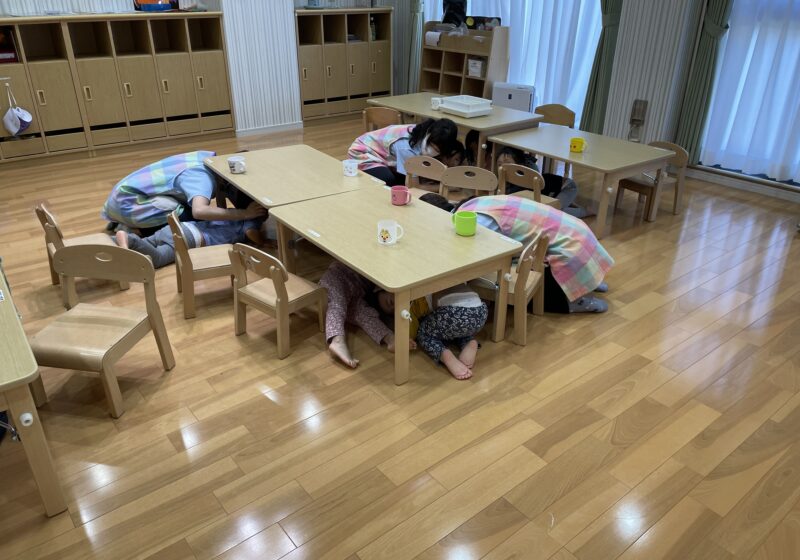 幼児クラスは机の下に入って身を守ります。