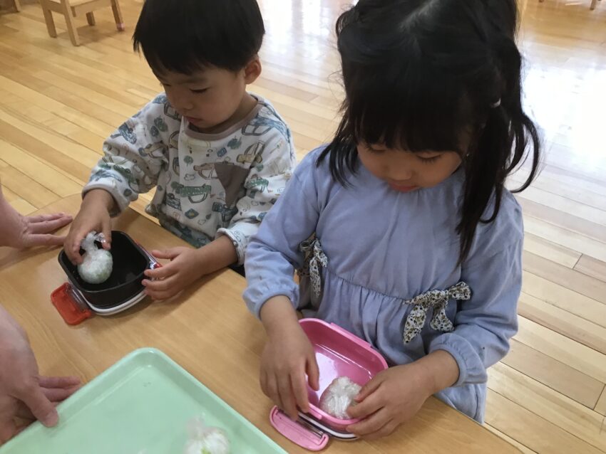 2歳児さんがお弁当作りをしました。<br />
保育園に自分のお弁当箱と水筒、レジャーシートを持ってきて、この日が来るのを待ち遠しく待っていました。