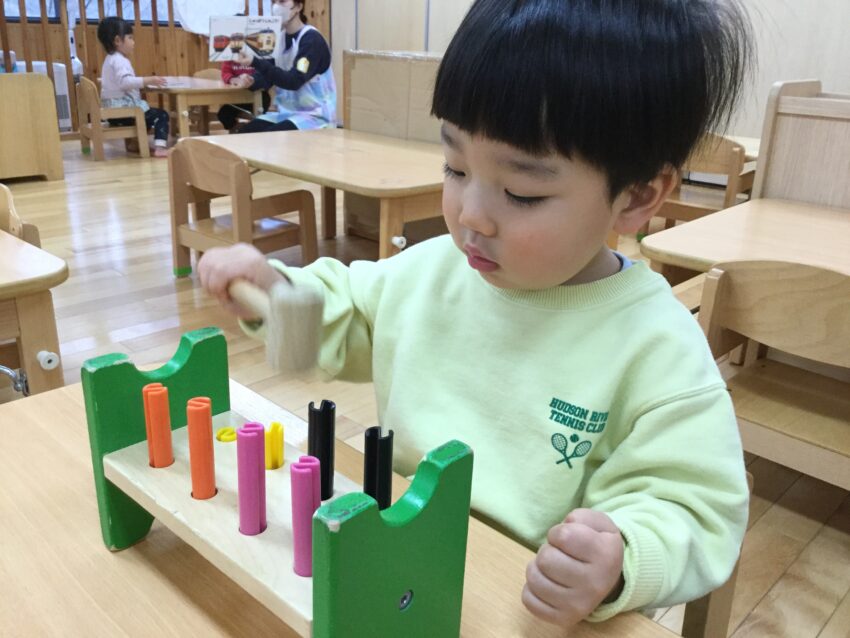 市ヶ谷保育園には様々な玩具があります。
特に１歳児さんは入れる、通す、落とす、並べる、積む、叩くことに夢中になります。
夢中になって遊んでいるうちに集中力が育まれていきます。