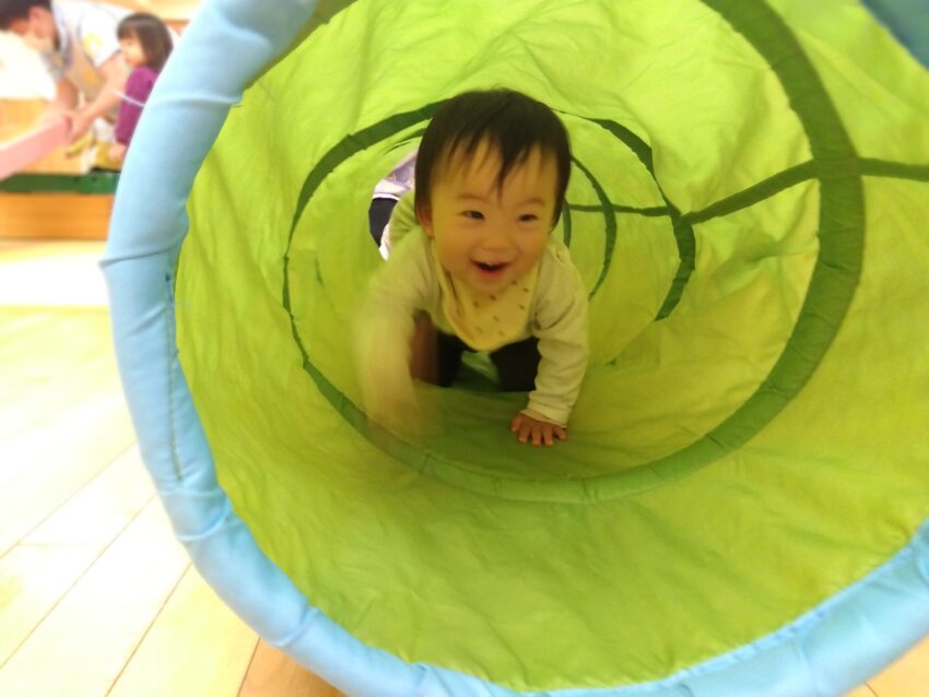 入園して1か月が過ぎて園の生活にも慣れてきた様子の1歳児さん。
様々な運動遊具にも興味を持ってきました。
市ヶ谷保育園では運動遊びも発達段階に合わせたねらいに沿って行っています。
5月は「くぐる」「登る」「ジャンプする」「ひっぱる」を経験出来るようにしていっています。