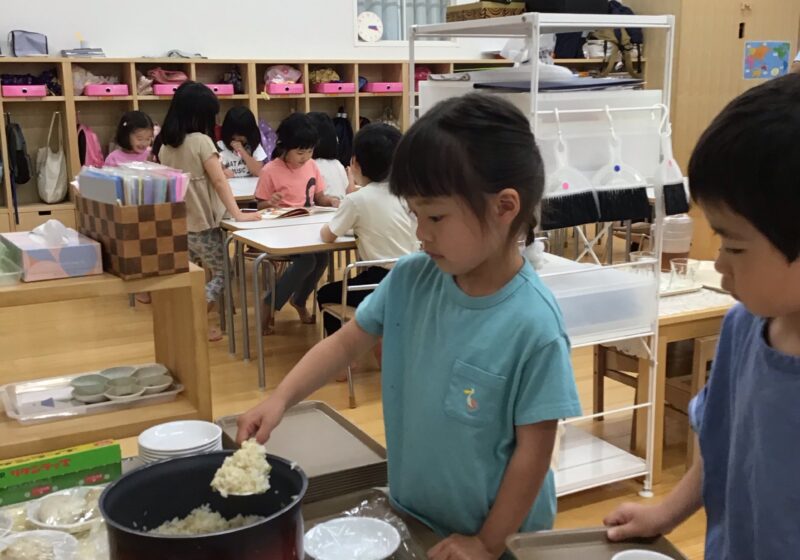 ラップを敷いたお皿にご飯をよそっていきます