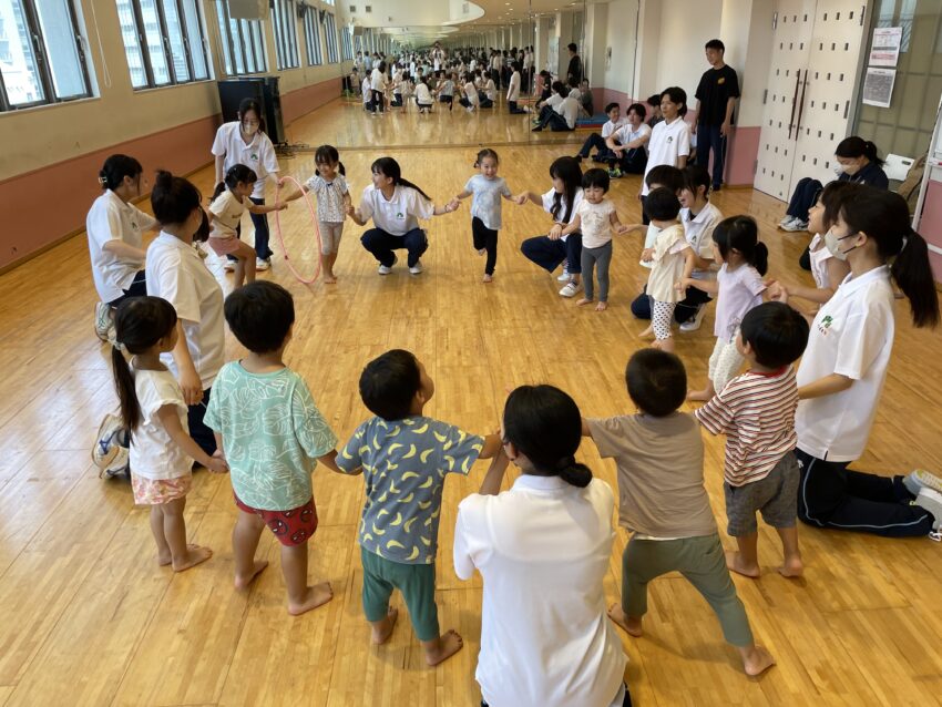 名古屋こども専門学校の学生さんによる体育活動に参加！<br />
みんなでフラフープを使って遊んだよ✨<br />
手をつないだまま体にフラフープを通せるかな～？ 