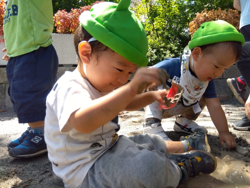 暑い日が続いていますが、気温の低い時間帯を見つけて、1歳児さんも公園に遊びに行っています。<br />
熱中症対策の為に先生が霧吹きを散歩途中でも子どもたちにかけてあげながら<br />
移動しています。<br />
公園に着いてからもお水で十分に遊べるような玩具を準備しています。<br />
思う存分お水や泥で遊んで満足そうな笑顔☺