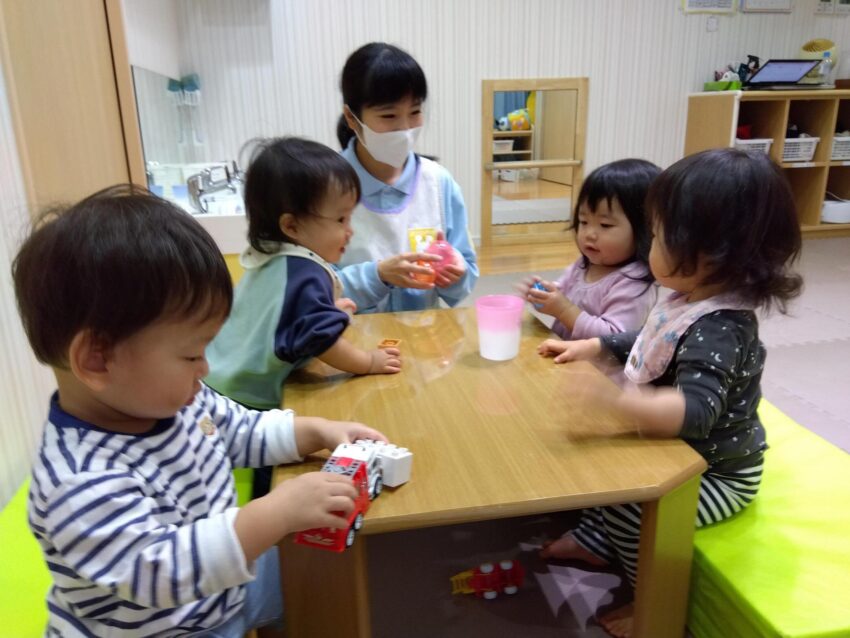 あいにく外は雨のため、保育室で過ごしました☔<br />
担任保育士が机の高さに合わせて椅子の代わりにマットを設置すると一人ひとりが好きなおもちゃを持ち寄って集まりました😌<br />
