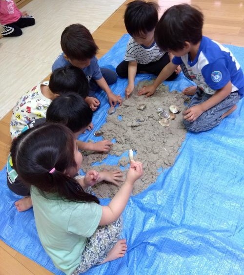 潮干狩りごっこをしました🐚
保育者が見本を見せながら、砂浜に貝が息をしている穴が開いているところを見つけて掘ってみると、貝が採れることを伝えていきました。
砂を掘るとたくさんの貝殻が✨
