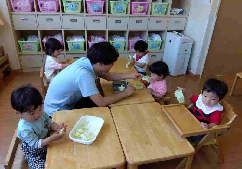 先生に丁寧にちぎり方を教えてもらっています。上手にちぎれるかな？
