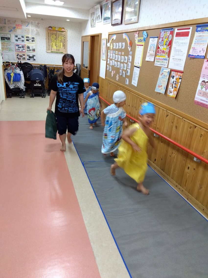 プールに入る前に、たんぽぽ組の沐浴室で、一人ずつ先生にシャワーをかけてもらいます。
滑り止めのマットの上を通って、先生と一緒にプールに向かいます。