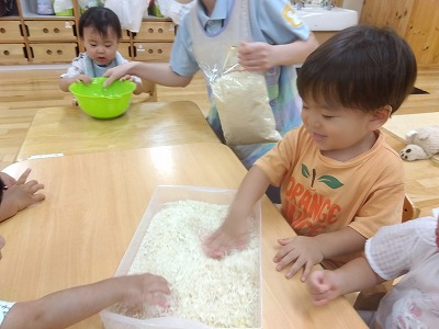 先生がバットやボールにパン粉を入れてくれました。サラサラする気持ちの良い感触に思わずにっこり。