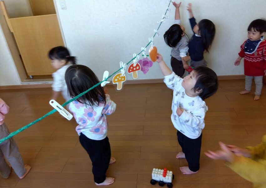 果物狩りも行い、思い切り手を伸ばして収穫楽しむ１歳児さん。