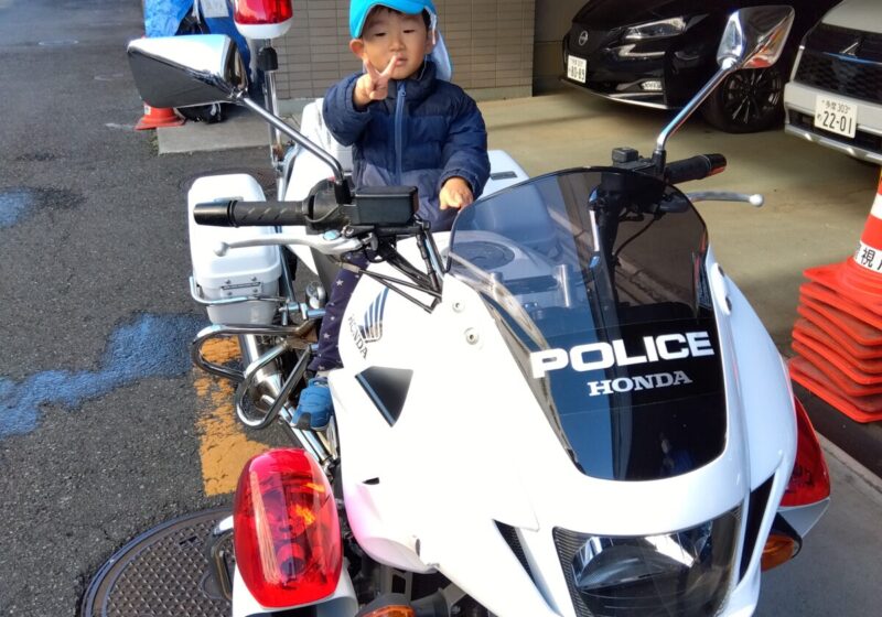 大きな白バイに乗って、ピース