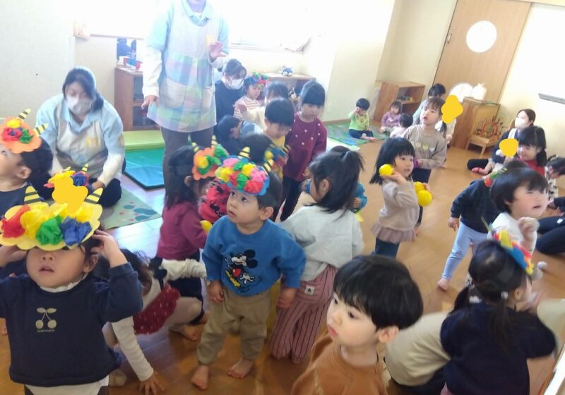 【豆まき】さぁ！鬼退治をしよう！「鬼はそとー」の掛け声に合わせて部屋いっぱいに広がった豆（ボール）を力いっぱい投げています。夢中になりすぎて身につけていたお面がずり落ちてしまうお友達もいました。