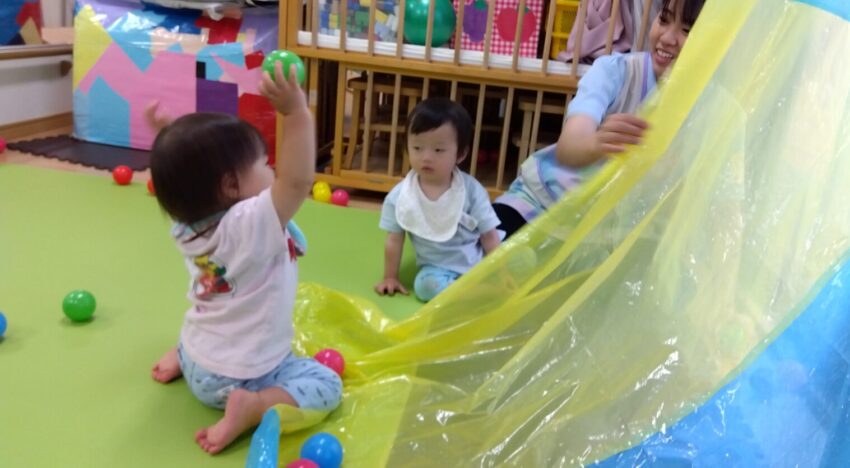 保育士が上からボールを転がして見せると、真似をして手を伸ばしています！転がってくる様子が面白いようです🔴